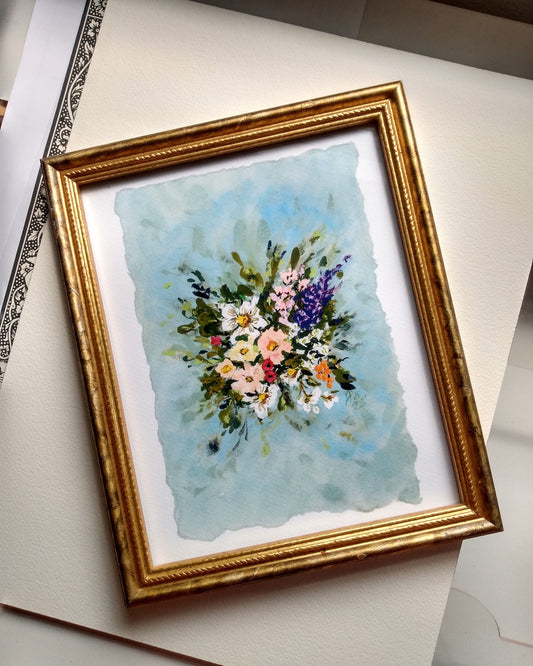 Framed watercolor painting of flowers on a white surface